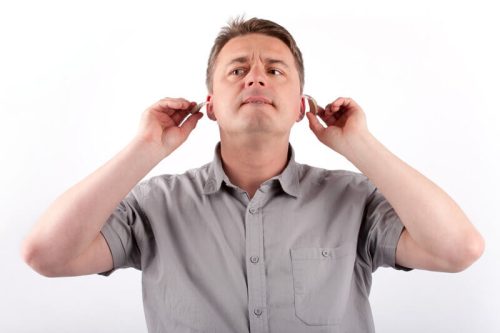 man fixing hearing aids