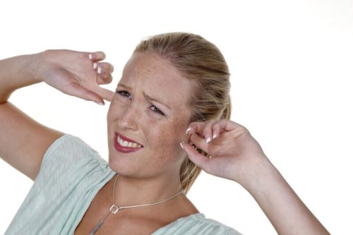 woman holding fingers in tinnitus ears